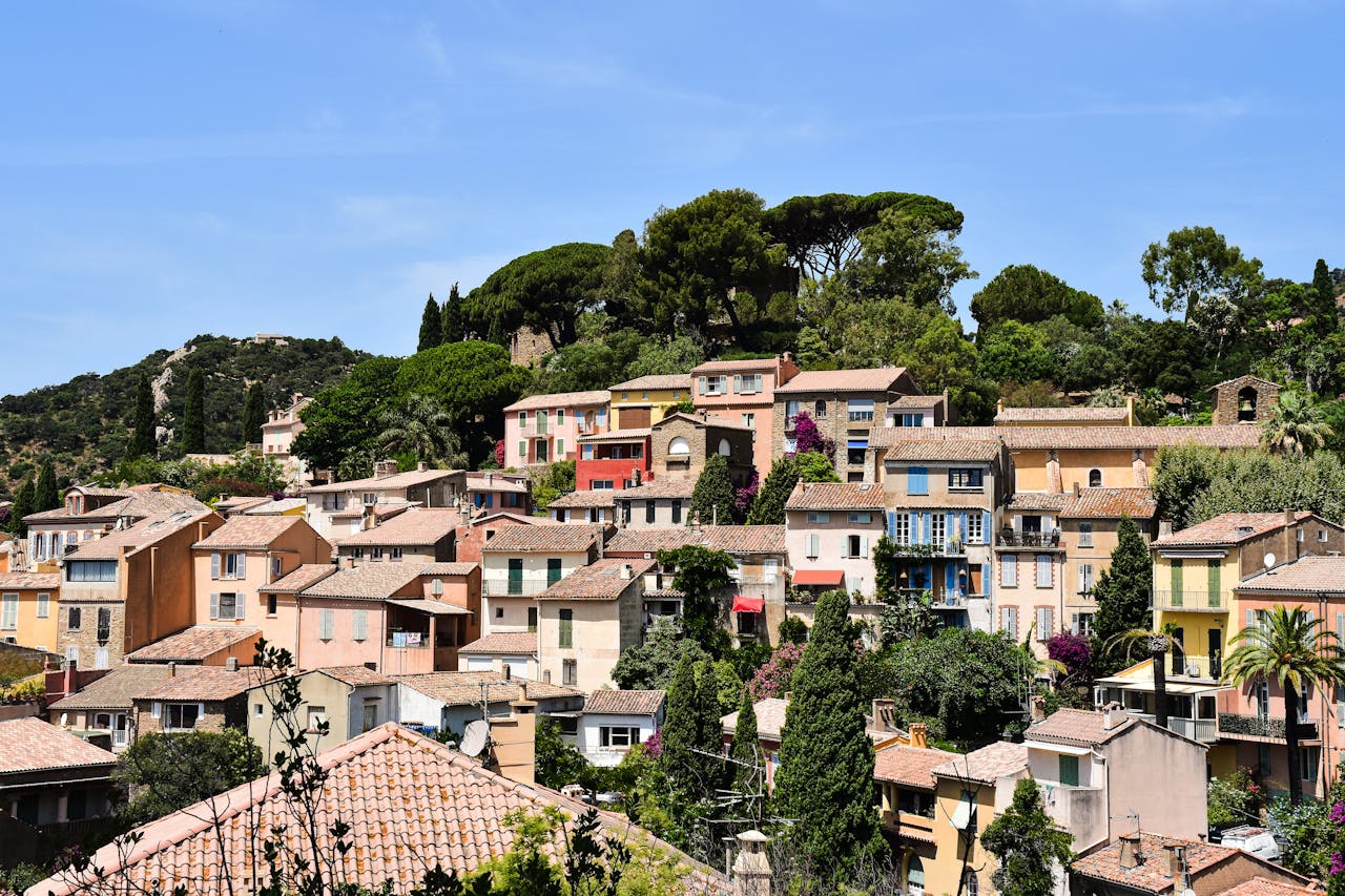 Picturesque view of colorful houses in Bormes-les-Mimosas, Provence, France under clear blue skies.